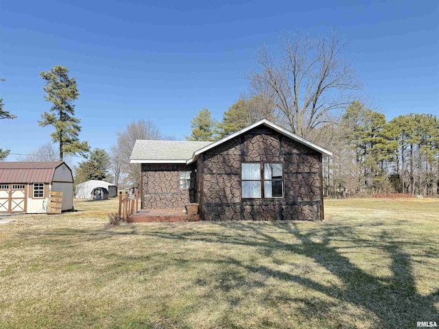 view of property exterior featuring stone siding, a storage shed, an outdoor structure, and a yard