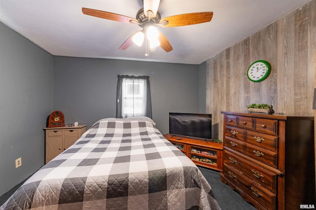 bedroom featuring carpet floors, wood walls, and a ceiling fan