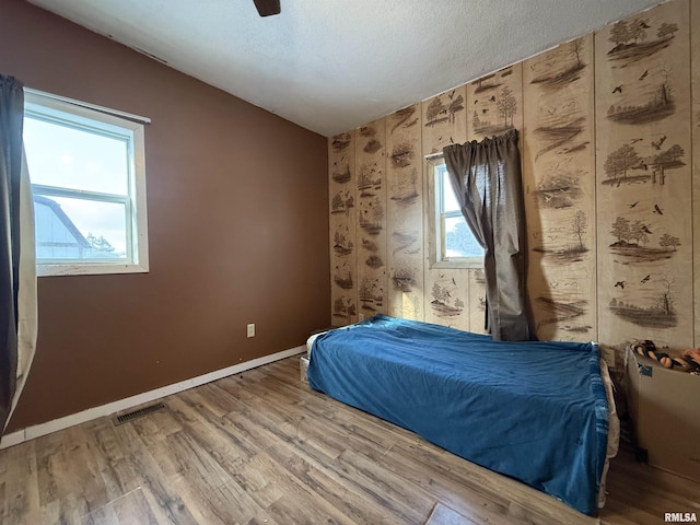 unfurnished bedroom featuring light wood-type flooring, baseboards, visible vents, and a textured ceiling