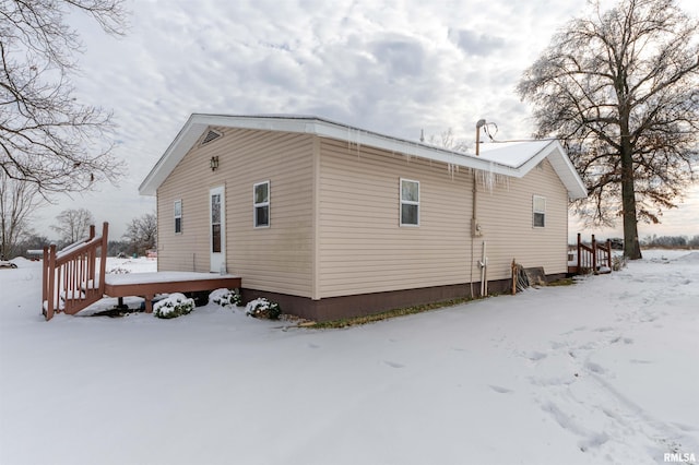 snow covered property featuring a wooden deck