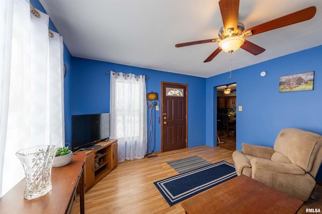 living room featuring light wood-style floors and a ceiling fan