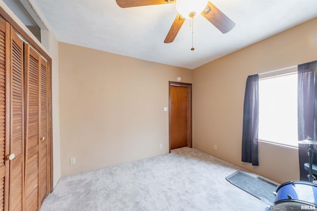 unfurnished bedroom featuring carpet floors, visible vents, and a ceiling fan