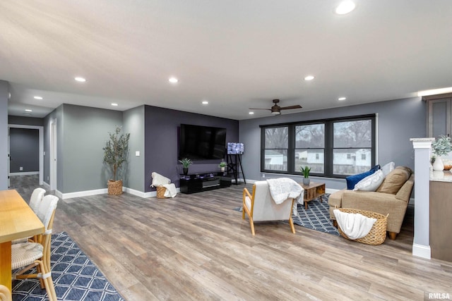 living area with baseboards, light wood-type flooring, and recessed lighting