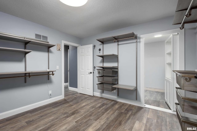 walk in closet featuring visible vents and wood finished floors