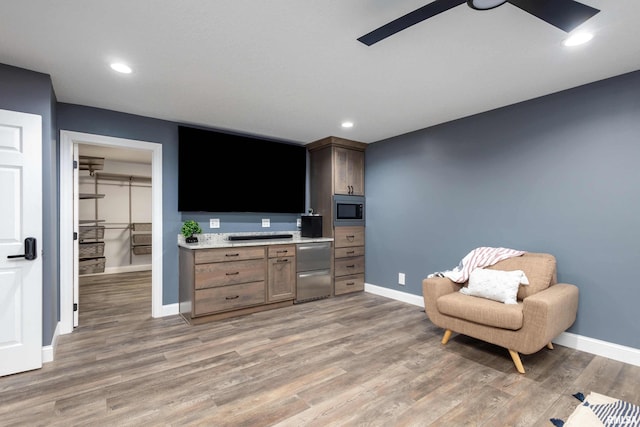 living area featuring light wood-style floors, recessed lighting, and baseboards