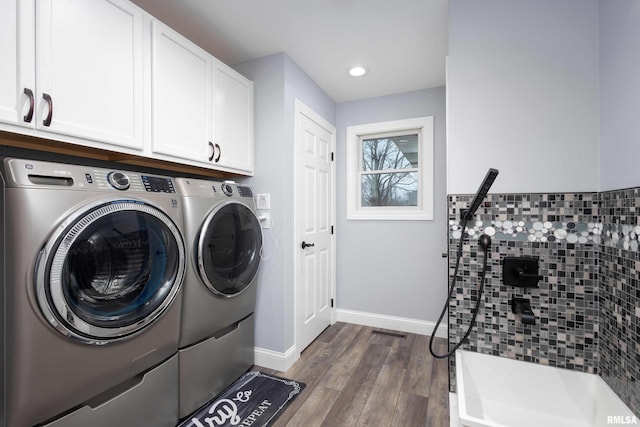 laundry room featuring dark wood-style floors, washing machine and clothes dryer, recessed lighting, cabinet space, and baseboards