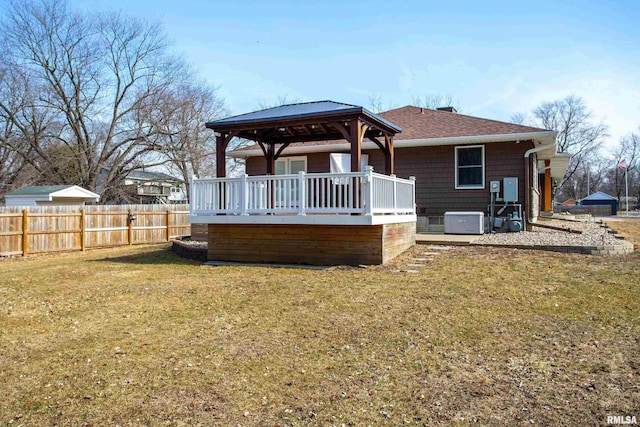 back of house with a gazebo, a yard, roof with shingles, and fence