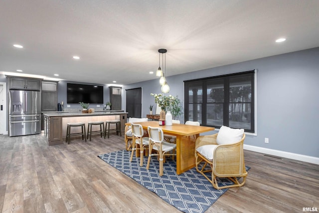 dining area with dark wood-type flooring, recessed lighting, visible vents, and baseboards