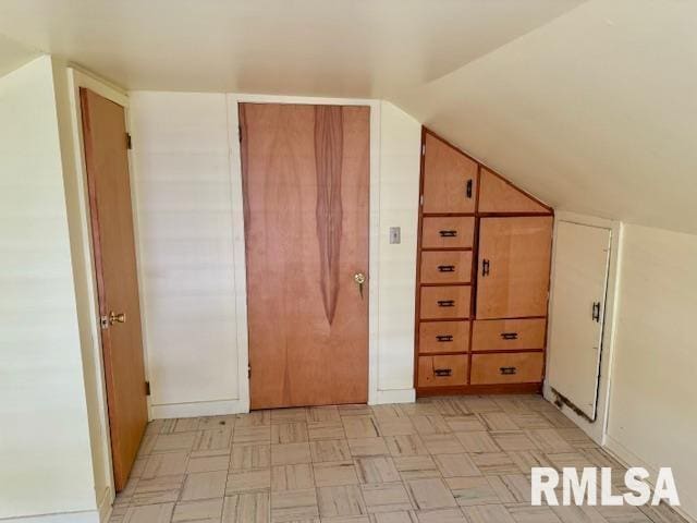 bonus room with vaulted ceiling and light floors