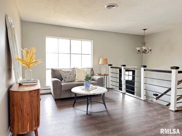 506 Timothy Ln, Carterville, IL 62918 - living area featuring a baseboard heating unit, dark wood-style flooring, a chandelier, and a textured ceiling