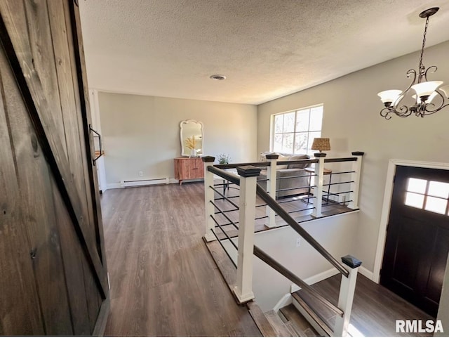 506 Timothy Ln, Carterville, IL 62918 - stairs with baseboard heating, a textured ceiling, wood finished floors, a chandelier, and baseboards