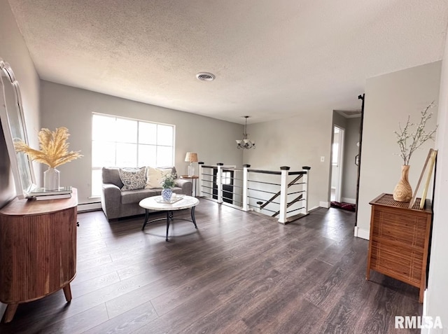 506 Timothy Ln, Carterville, IL 62918 - living room featuring a textured ceiling, dark wood finished floors, a baseboard radiator, a chandelier, and baseboards