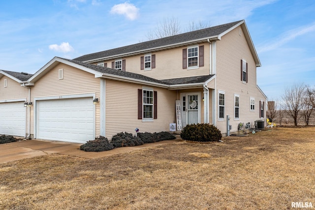 traditional home with a garage, concrete driveway, a front lawn, and central air condition unit