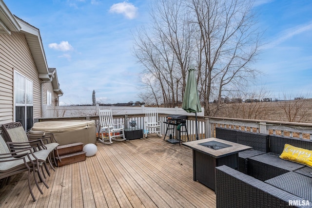 deck with an outdoor living space with a fire pit and a hot tub