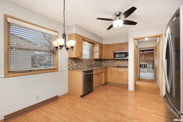 kitchen with decorative backsplash, light wood-style flooring, appliances with stainless steel finishes, light brown cabinets, and pendant lighting