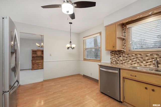 kitchen with decorative backsplash, decorative light fixtures, stainless steel appliances, light wood-type flooring, and a sink