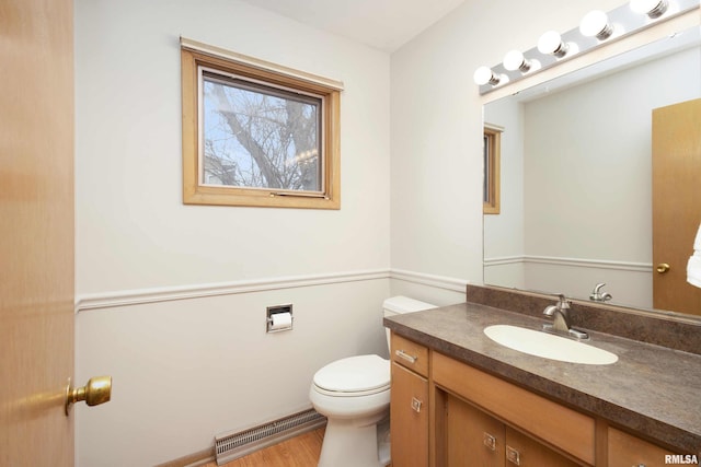 half bath featuring toilet, wood finished floors, vanity, and visible vents