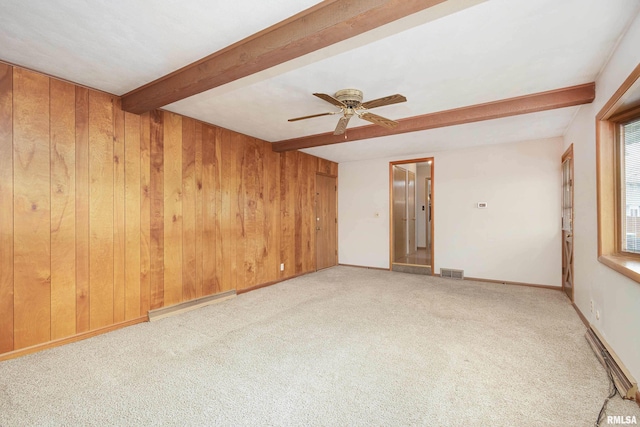 unfurnished room featuring light colored carpet, visible vents, beamed ceiling, and wooden walls