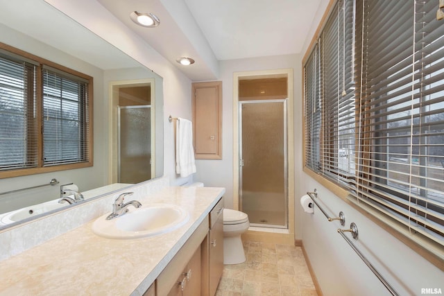 bathroom featuring a stall shower, vanity, and toilet