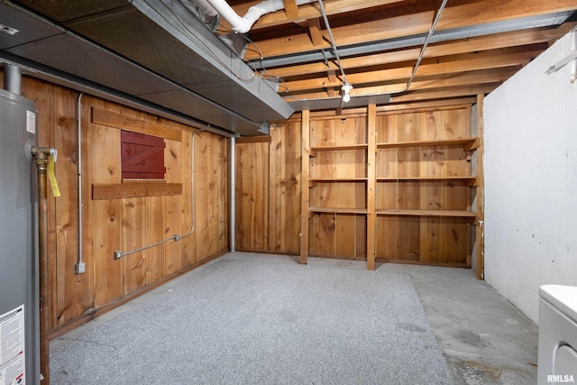 unfinished below grade area featuring wooden walls and water heater