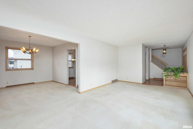 unfurnished living room featuring a chandelier, stairway, carpet flooring, and visible vents