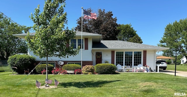 tri-level home featuring a front lawn and brick siding