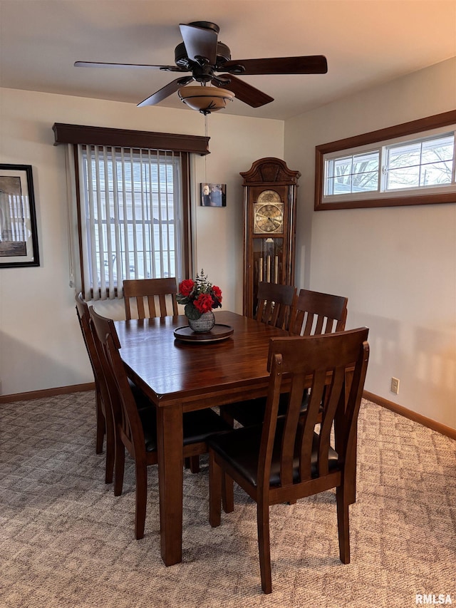 carpeted dining area featuring ceiling fan and baseboards