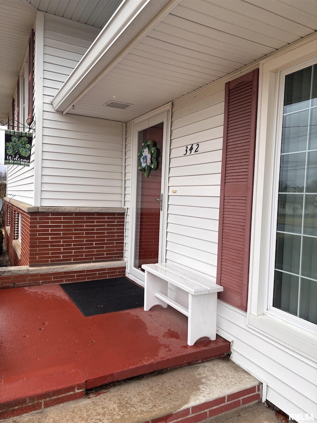 view of exterior entry featuring covered porch