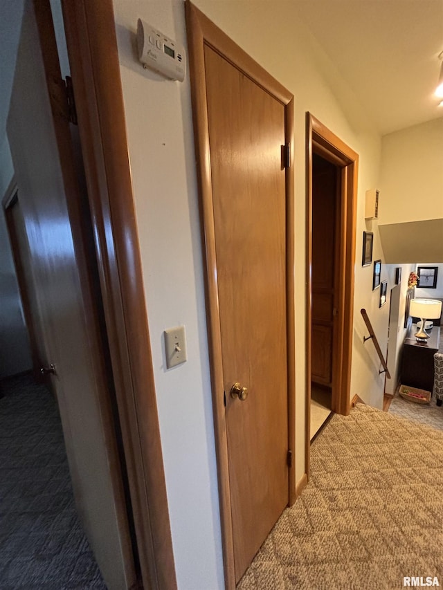 hall featuring light carpet and an upstairs landing