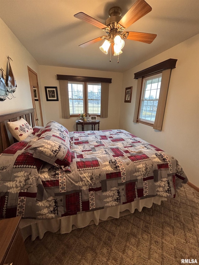 carpeted bedroom featuring multiple windows and a ceiling fan