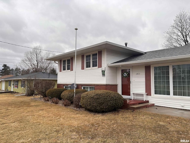 split level home with brick siding and a front yard