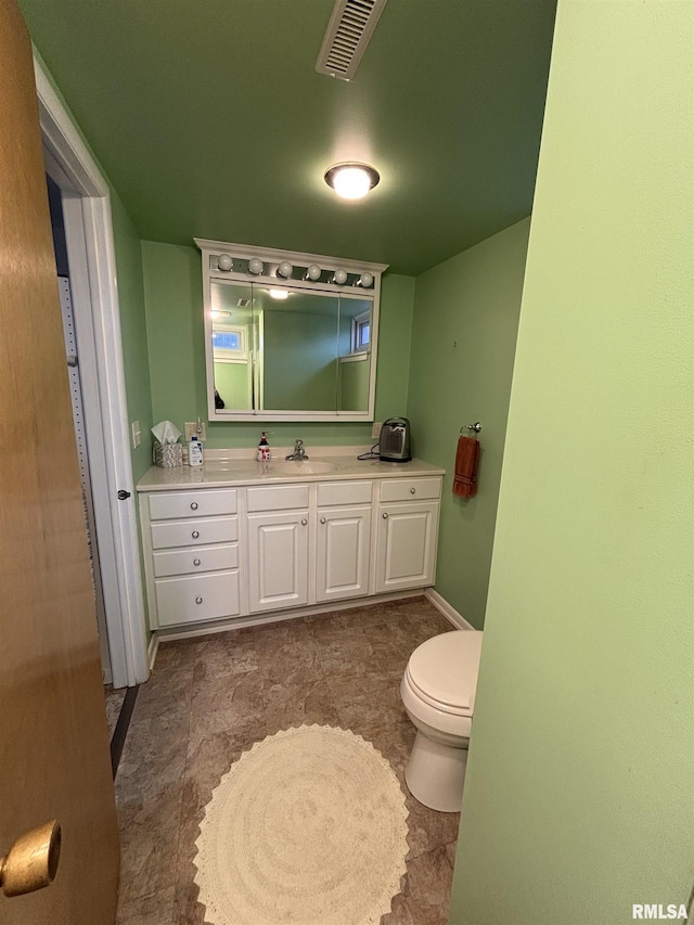 bathroom with visible vents, vanity, and toilet