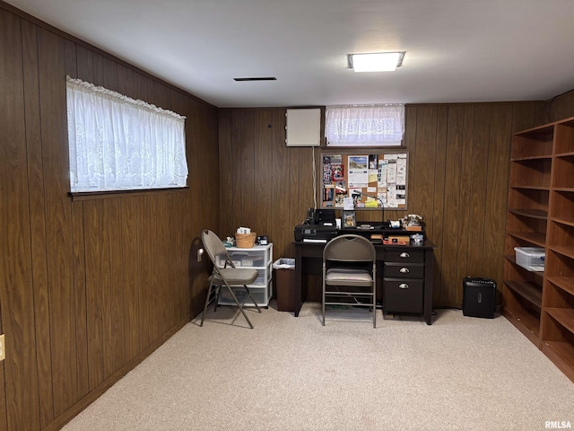 office space featuring light carpet and wood walls