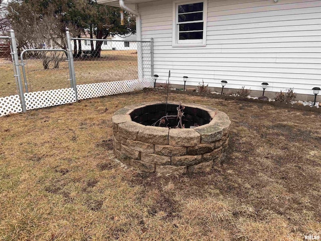 view of yard with an outdoor fire pit and fence