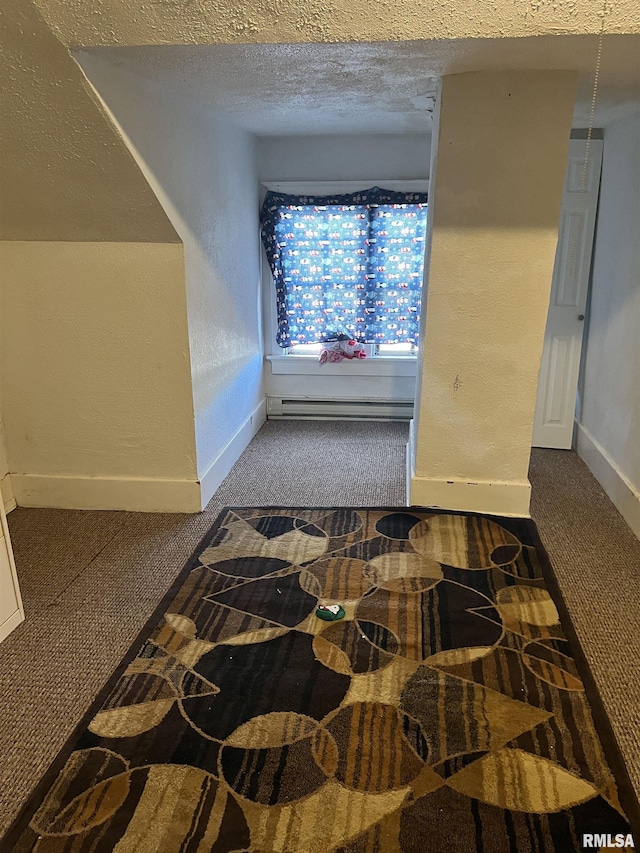 hall with carpet, baseboards, a textured ceiling, and baseboard heating