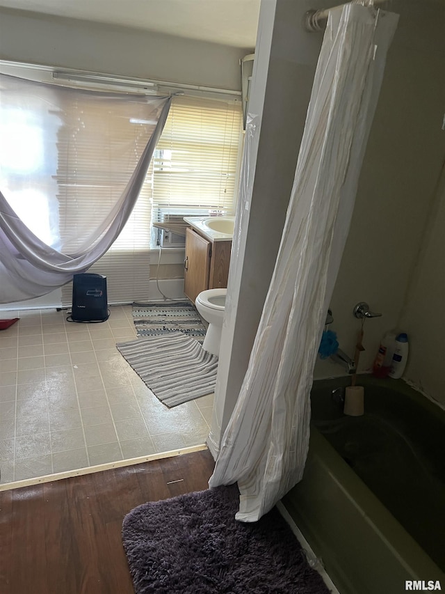 bathroom featuring shower / bath combo with shower curtain, vanity, and wood finished floors