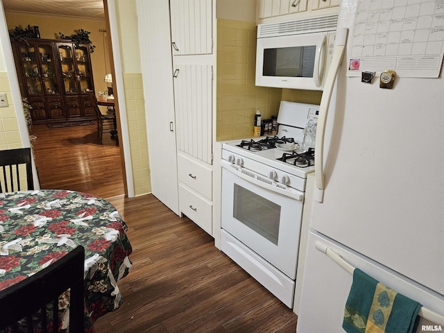 kitchen with white cabinets, white appliances, dark wood finished floors, and tile walls