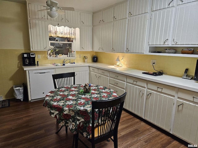 kitchen with dark wood-type flooring, light countertops, dishwasher, and a sink