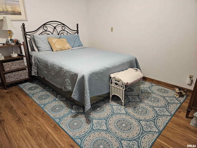 bedroom with baseboards and wood finished floors