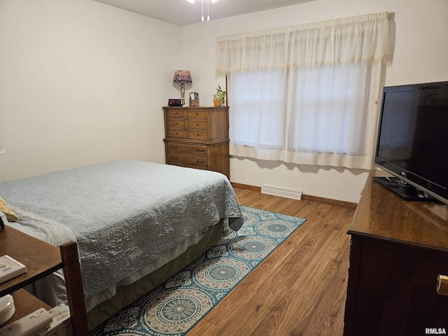 bedroom with visible vents, baseboards, and wood finished floors