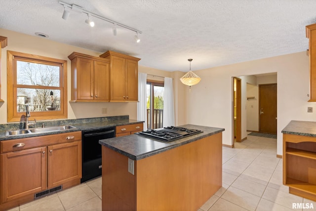 kitchen featuring black dishwasher, visible vents, dark countertops, stainless steel gas stovetop, and a sink