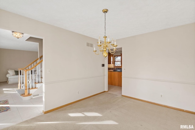 unfurnished dining area featuring a notable chandelier, visible vents, a sink, baseboards, and stairs