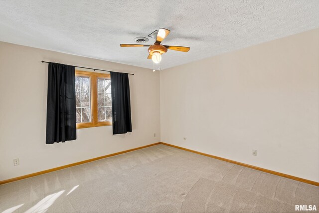 spare room featuring a ceiling fan, baseboards, a textured ceiling, and light colored carpet