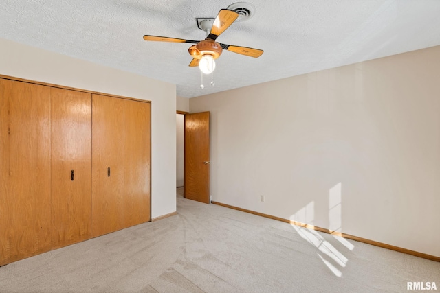 unfurnished bedroom featuring a textured ceiling, a closet, carpet flooring, and baseboards