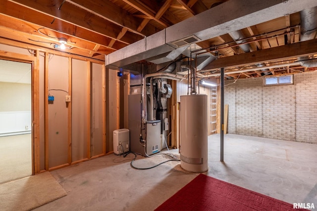 below grade area with brick wall, water heater, visible vents, and heating unit