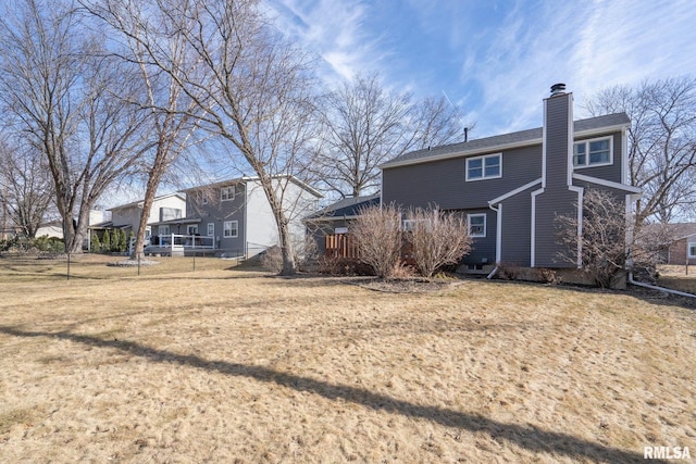 rear view of house with a yard and a chimney