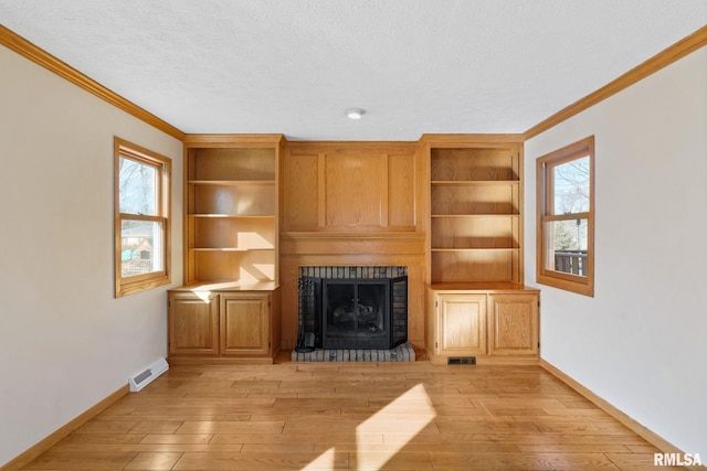 unfurnished living room with a brick fireplace, baseboards, ornamental molding, a textured ceiling, and light wood-style floors