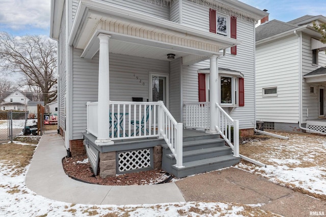 snow covered property entrance featuring a porch