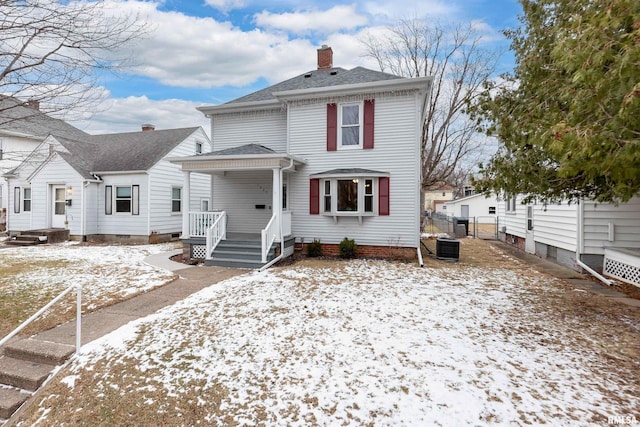 view of front of property featuring a chimney, roof with shingles, fence, a porch, and central AC