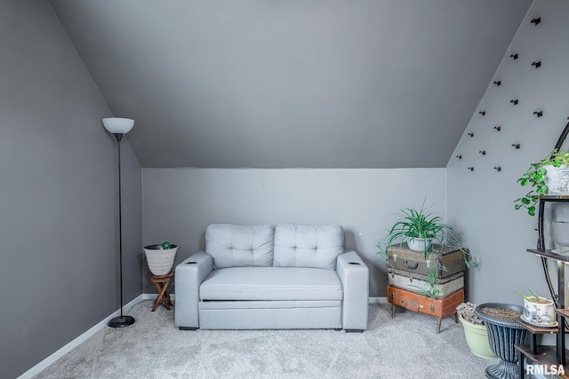 sitting room featuring lofted ceiling, baseboards, and carpet flooring